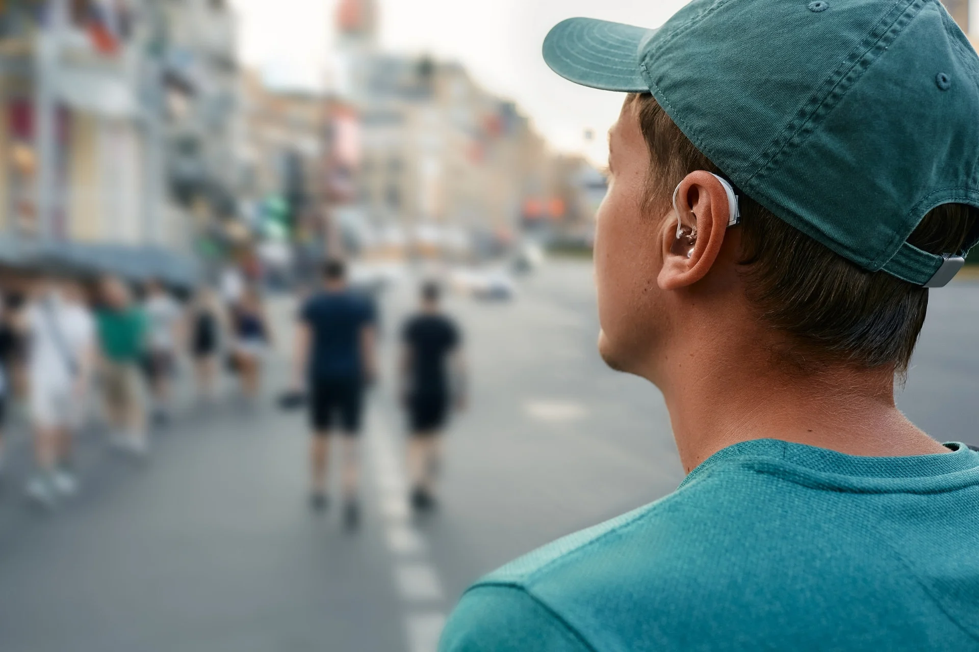 Person wearing a hearing aid while walking through a busy city street